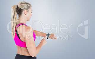 Composite image of female athlete using her smart watch