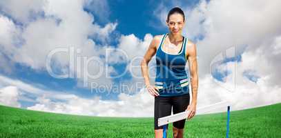Composite image of portrait of sportswoman posing next to hurdle