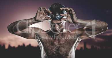 Composite image of swimmer holding swimming goggles