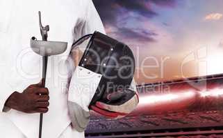Composite image of mid-section of man standing with fencing mask