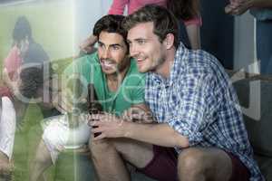 Composite image of friends are watching rugby match on televisio