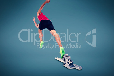 Composite image of male athlete running from starting blocks