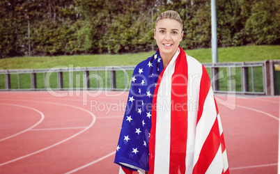 Female athlete with american flag on her shoulders