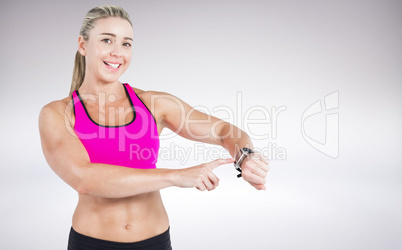 Composite image of female athlete using her smart watch