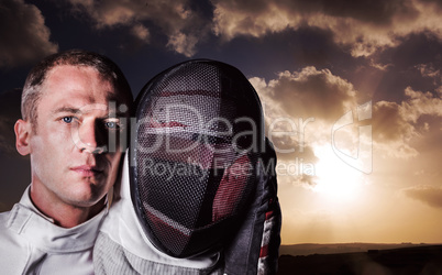 Composite image of close-up of swordsman holding fencing mask