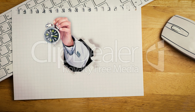 Composite image of hand holding alarm clock
