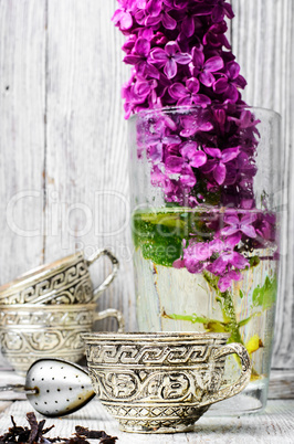 Still life with tea and branch of lilac