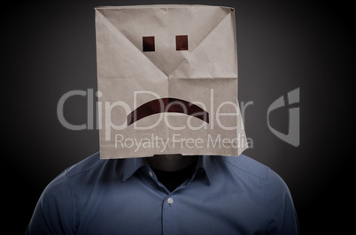 Businessman with an unhappy face on a paper bag