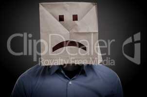 Businessman with an unhappy face on a paper bag
