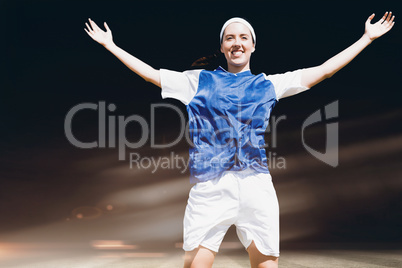 Composite image of front view of happy sportswoman raising her a