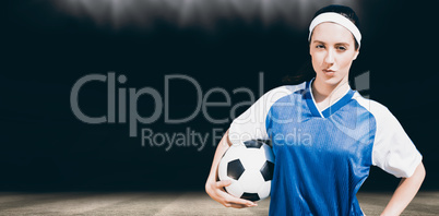Composite image of woman football player posing with football on