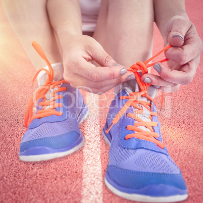 Composite image of portrait of athlete woman tying her running s