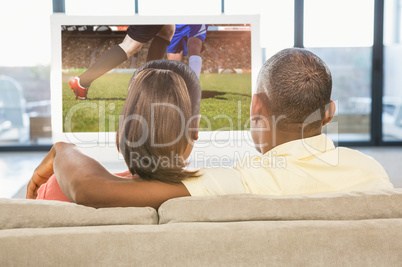 Composite image of over shoulder view of casual couple watching