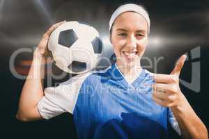 Composite image of portrait of happy woman football player holdi