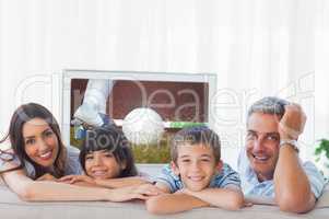 Composite image of family in sitting room smiling at camera