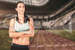 Composite image of sporty woman posing with her arms crossed