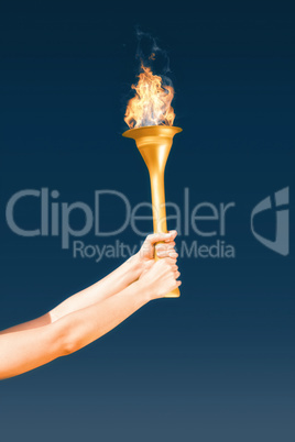 Composite image of sporty woman holding olympic torch
