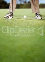 Golfer placing golf ball on tee