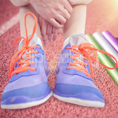 Composite image of athlete woman sitting with sports shoes