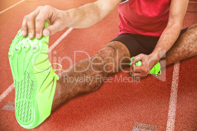 Composite image of portrait of male athlete doing stretching exe