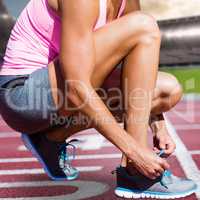 Composite image of close up of sportswoman is lacing shoes