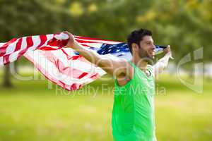 Composite image of happy sportsman holding a american flag