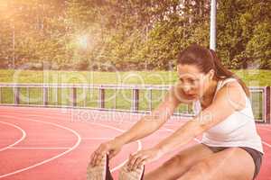 Composite image of athlete woman doing stretching exercise