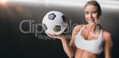 Composite image of female athlete holding a soccer ball