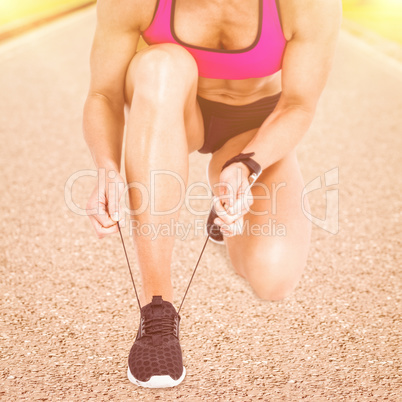 Composite image of  female athlete tying her shoelace