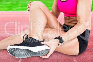 Composite image of injured female athlete sitting and removing h