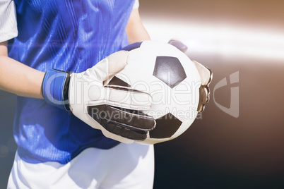 Composite image of close up of a football held by sportswoman