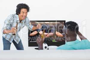 Composite image of soccer fans watching tv