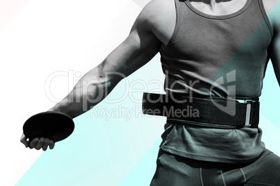 Composite image of close up on sportsman chest practising discus