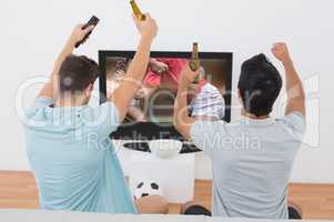 Composite image of excited soccer fans watching tv