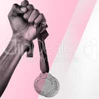 Composite image of hand holding two gold medals on white backgro