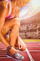 Composite image of portrait of sportswoman lacing her shoes