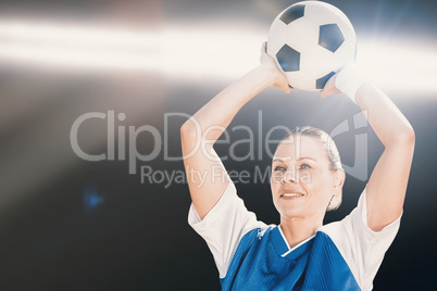 Composite image of woman soccer player holding a ball