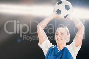 Composite image of woman soccer player holding a ball