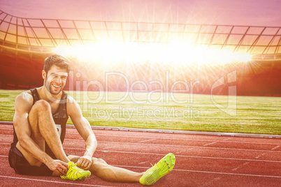 Composite image of sportsman smiling and lacing shoes