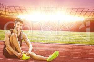 Composite image of sportsman smiling and lacing shoes