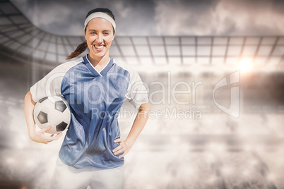 Composite image of portrait of happy woman football player holdi