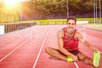 Composite image of portrait of male athlete stretching his hamst