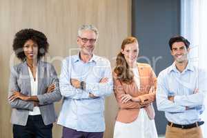 Portrait of smiling business people standing together with arms