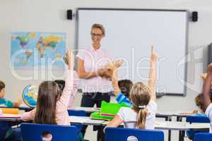 Pupils with hands up during lesson