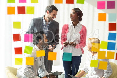 Business people discussing over adhesive notes