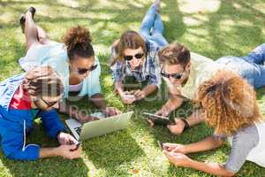 Group of friends using laptop, mobile phone and digital tablet