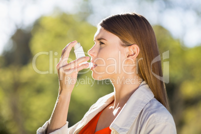 Woman using asthma inhaler