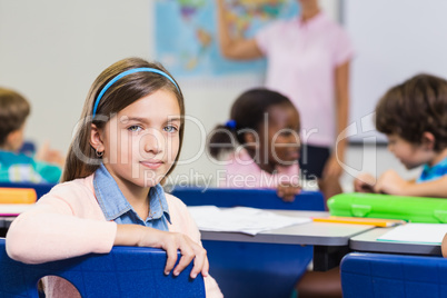 Cute pupil looking at camera during lesson