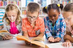 Kids reading a book in library