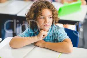 Thoughtful boy looking away while studying